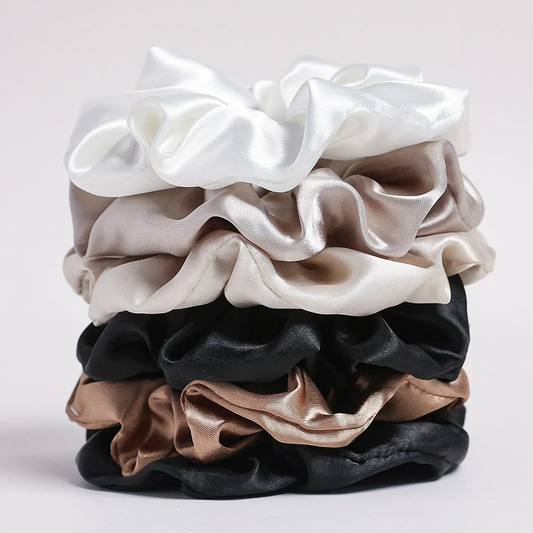 stack of satin scrunchies in pastel and neutral colors