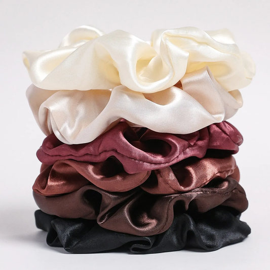 stack of satin scrunchies in pastel and neutral colors